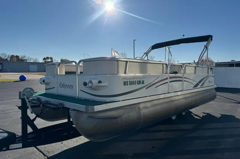 Slide: The Image of 2003 Odyssey Pontoons 2102 Millennium boat on trailer under clear blue sky. - 2