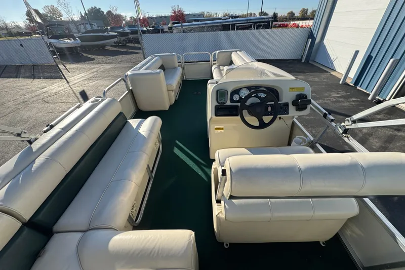 Slide: The Image of 2003 Odyssey Pontoons 2102 Millennium interior with white seating and steering console. - 24