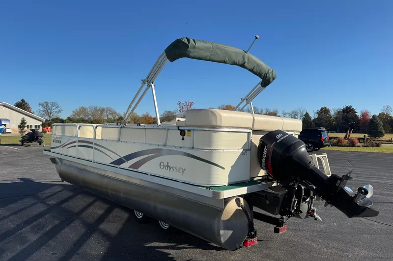 Slide: The Image of 2003 Odyssey Pontoons 2102 Millennium boat with canopy and outboard motor on pavement. - 3