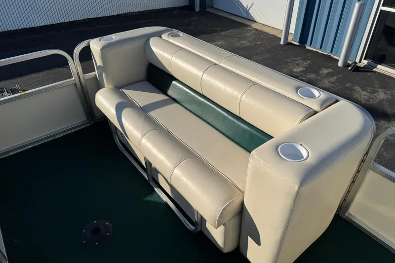 Slide: The Image of 2003 Odyssey Pontoons 2102 Millennium boat seating with cup holders, beige and green upholstery. - 6