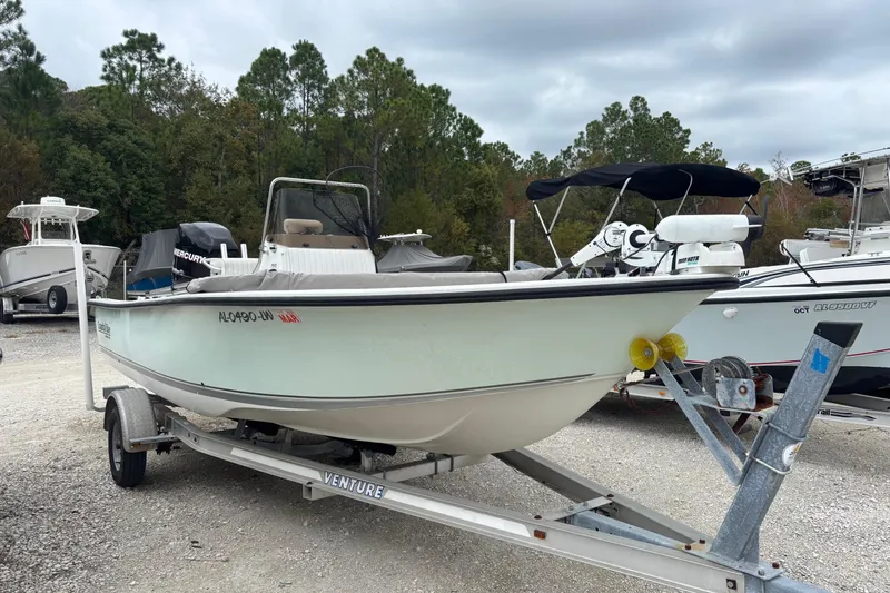 Slide: The Image of 2007 Action Craft Coastal Craft boat on trailer, parked outdoors with other boats. - 2