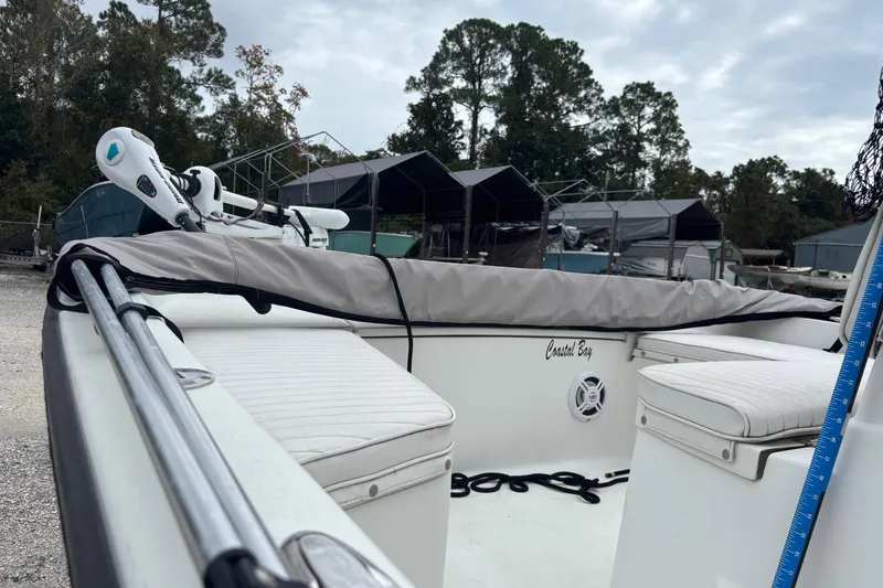 Slide: The Image of 2007 Action Craft Coastal Craft boat with cushioned seating and motor, parked outdoors. - 3