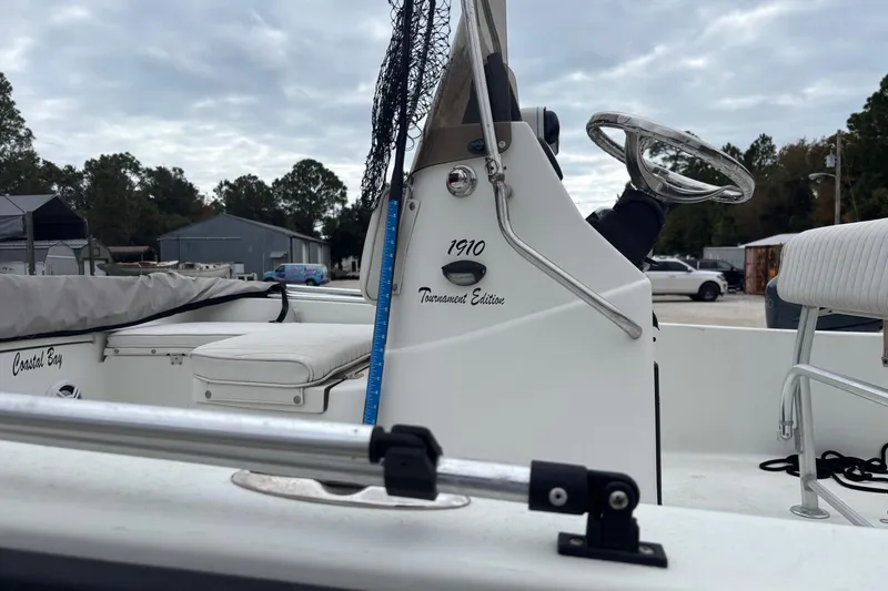 Slide: The Image of 2007 Action Craft Coastal Craft boat interior with steering wheel and seating, under cloudy sky. - 4