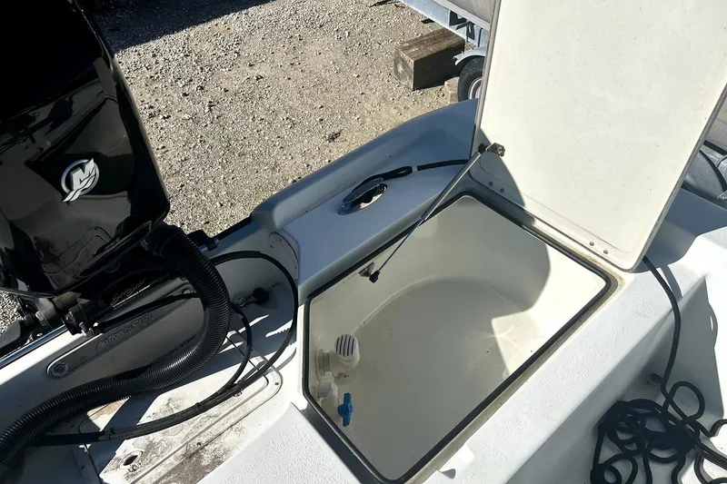 Slide: The Image of 2007 Action Craft Coastal Bay boat with open storage compartment and engine detail. - 7