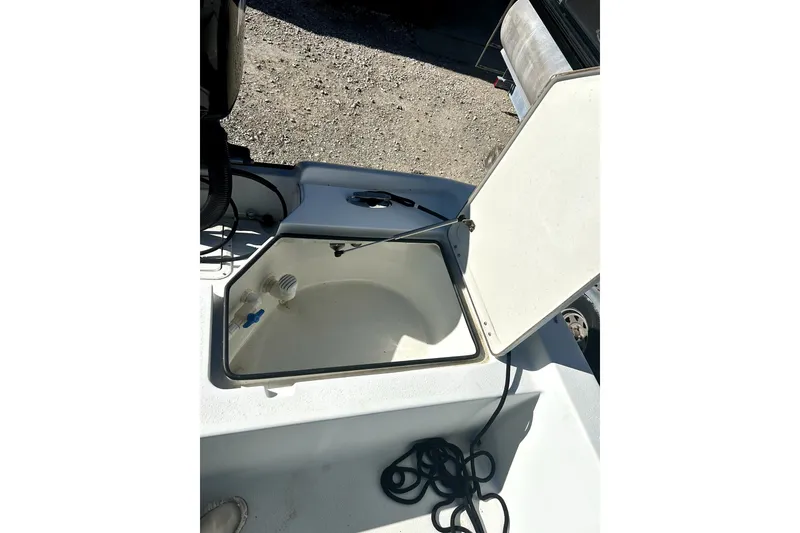 Slide: The Image of 2007 Action Craft Coastal Bay boat storage compartment with open lid and coiled rope. - 8