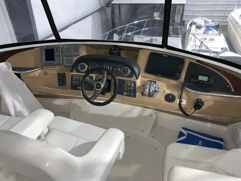 Slide: The Image of 2001 Carver 396 Motor Yacht helm with modern navigation equipment and white seating. - 11