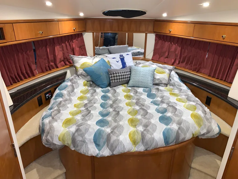 Slide: The Image of Luxurious bedroom interior of 2001 Carver 396 Motor Yacht with colorful bedding and wood accents. - 36