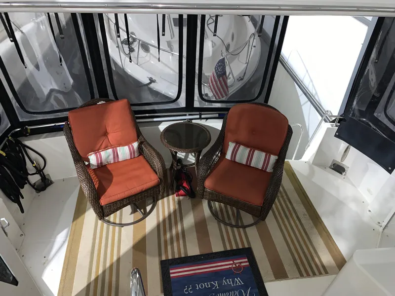 Slide: The Image of 2001 Carver 396 Motor Yacht interior with two wicker chairs and a small table. - 16