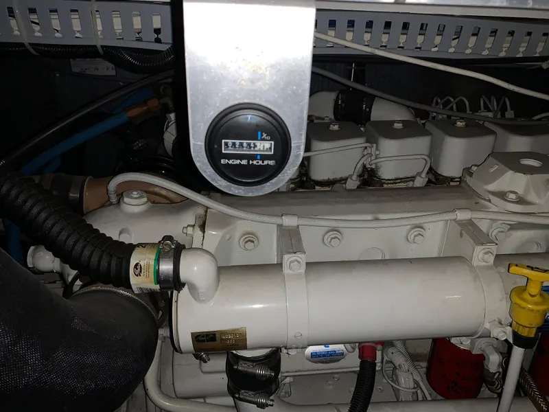 Slide: The Image of Engine compartment of 2001 Carver 396 Motor Yacht, featuring engine hour meter and components. - 18