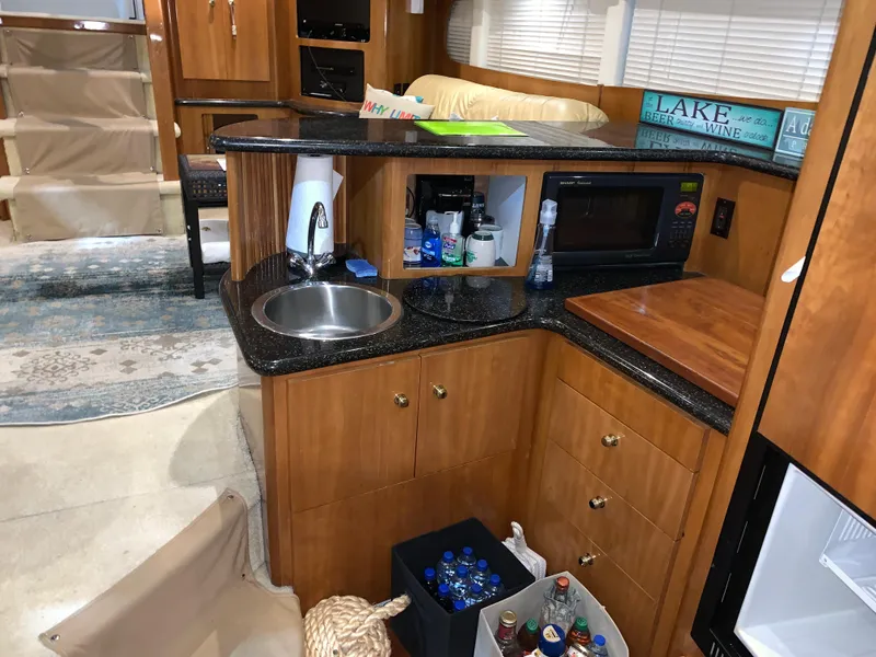 Slide: The Image of 2001 Carver 396 Motor Yacht kitchen with sink, microwave, and storage cabinets. - 29