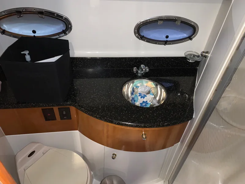 Slide: The Image of 2001 Carver 396 Motor Yacht bathroom with sink, countertop, and porthole windows. - 34