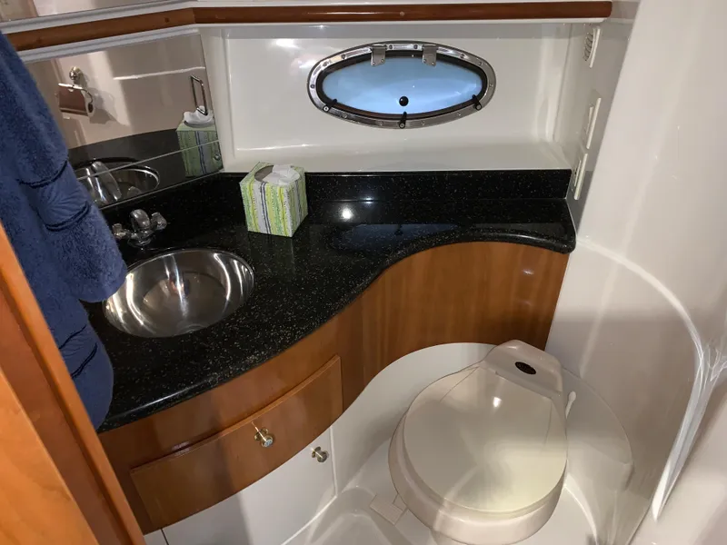 Slide: The Image of 2001 Carver 396 Motor Yacht bathroom with sink, toilet, and porthole window. - 37