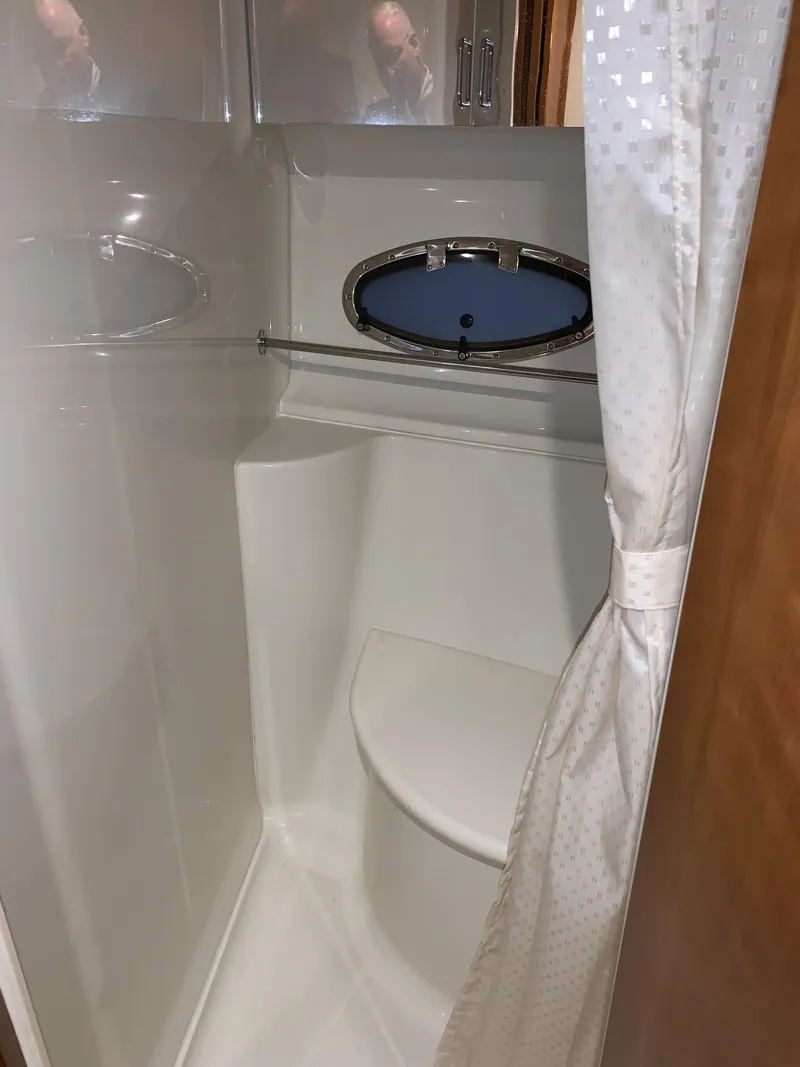 Slide: The Image of 2001 Carver 396 Motor Yacht bathroom with shower, curtain, and porthole window. - 38