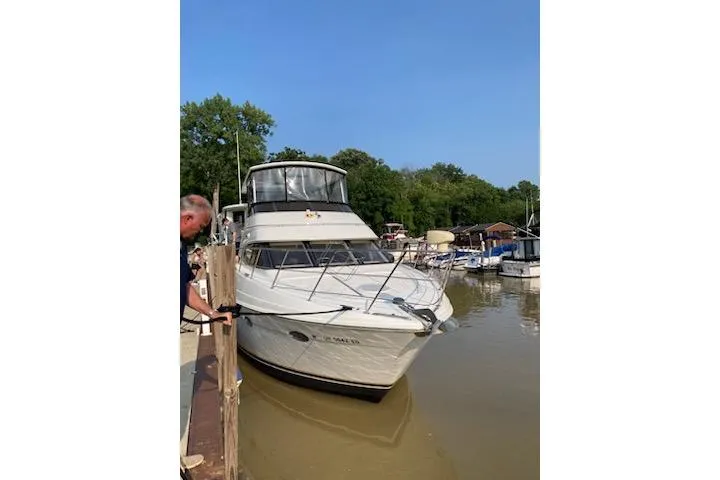 Slide: The Image of 2001 Carver 396 Motor Yacht docked at a marina, surrounded by trees and boats. - 39