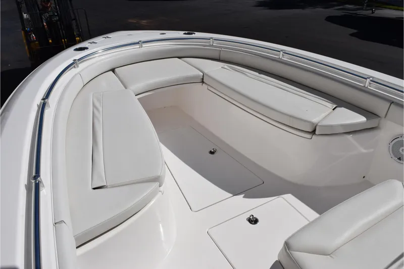 Slide: The Image of 2024 Contender 24 Sport boat interior with white cushioned seating and stainless steel railings. - 11