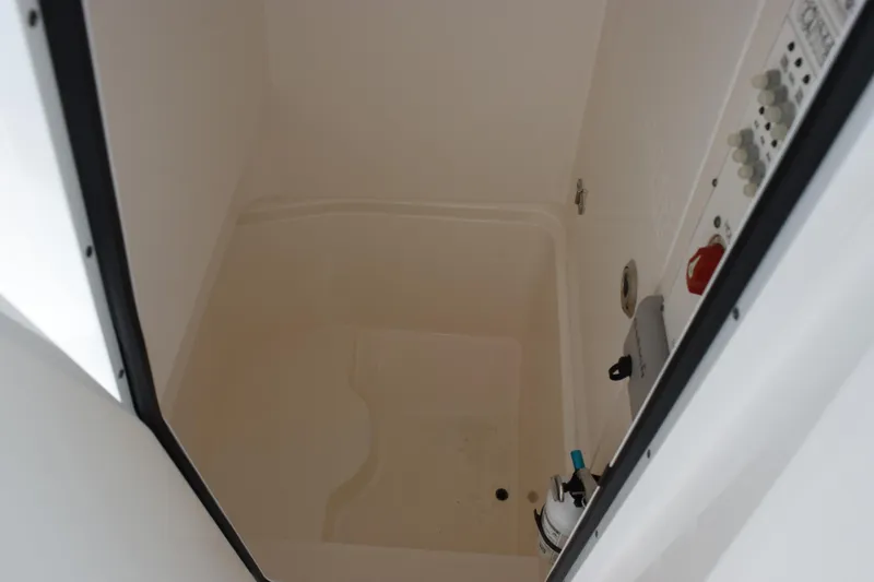 Slide: The Image of 2024 Contender 24 Sport boat storage compartment with control panel and equipment. - 14