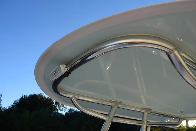 Slide: The Image of 2024 Contender 24 Sport boat T-top with stainless steel frame under clear blue sky. - 16