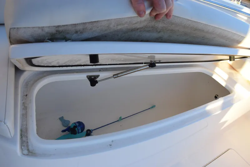 Slide: The Image of Open storage compartment on 2024 Contender 24 Sport boat, showing interior details. - 17