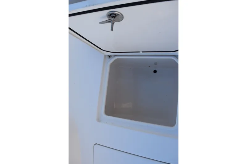 Slide: The Image of 2024 Contender 24 Sport boat storage compartment with secure latch. - 19