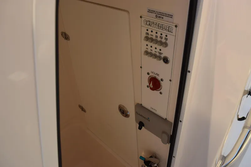 Slide: The Image of 2024 Contender 24 Sport boat control panel with switches and Garmin device. - 22