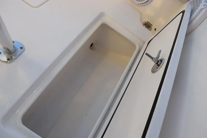 Slide: The Image of Open storage compartment on 2024 Contender 24 Sport boat deck. - 23