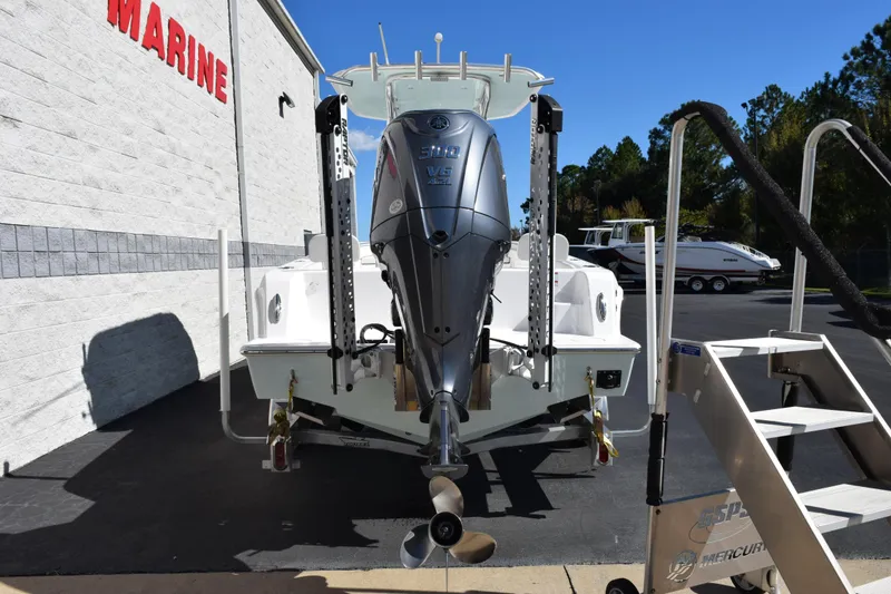 Slide: The Image of 2024 Contender 24 Sport boat with powerful outboard motor at a marine dealership. - 4