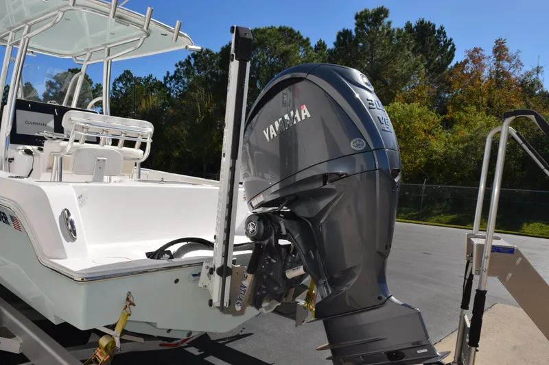 Slide: The Image of 2024 Contender 24 Sport boat with Yamaha outboard motor, parked outdoors. - 6