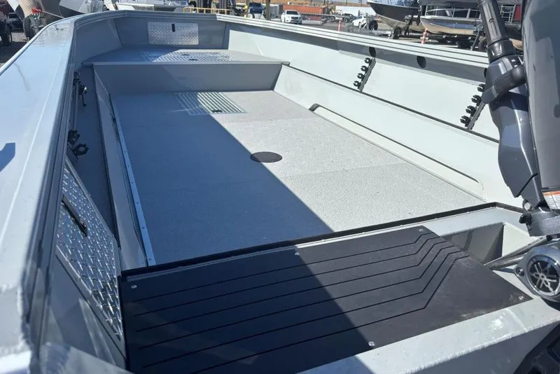 Slide: The Image of 2026 Smoker Craft Pro Sportsman 2072 T boat interior with spacious deck and motor. - 2