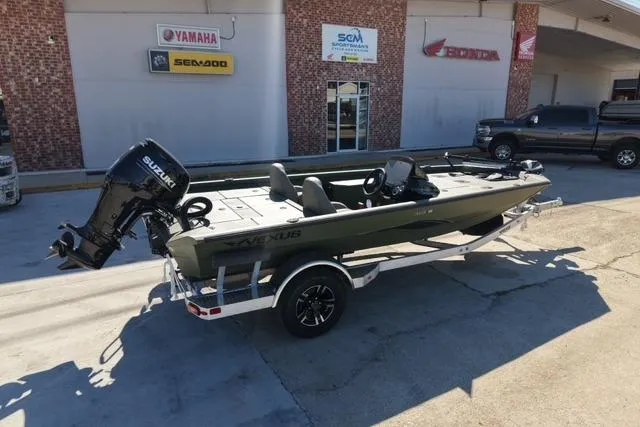 Slide: The Image of 2026 Vexus AVX181 boat with Suzuki engine on trailer, parked outside dealership. - 2