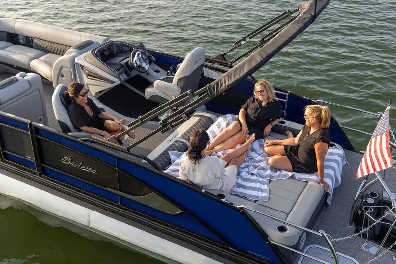 Slide: The Image of 2025 Barletta L23UC pontoon boat with four people relaxing on deck. - 8
