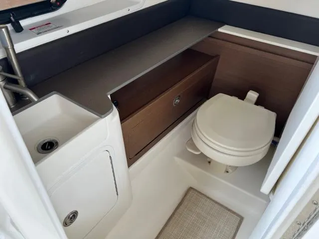 Slide: The Image of 2016 Sea Ray SDX 290 boat bathroom with sink, toilet, and storage cabinet. - 12