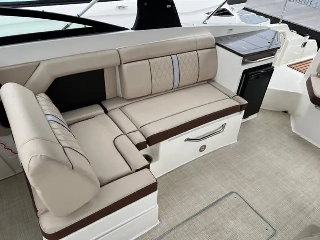 Slide: The Image of 2016 Sea Ray SDX 290 boat interior with beige seating and compact kitchenette. - 14
