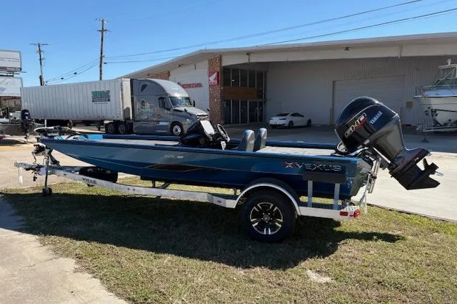 Slide: The Image of 2026 Vexus AVX181 boat on trailer, parked outdoors near a warehouse. - 1