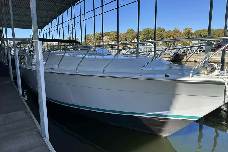 The Image of 1993 Mainship 39 Express boat docked in a marina under a covered structure. - 0