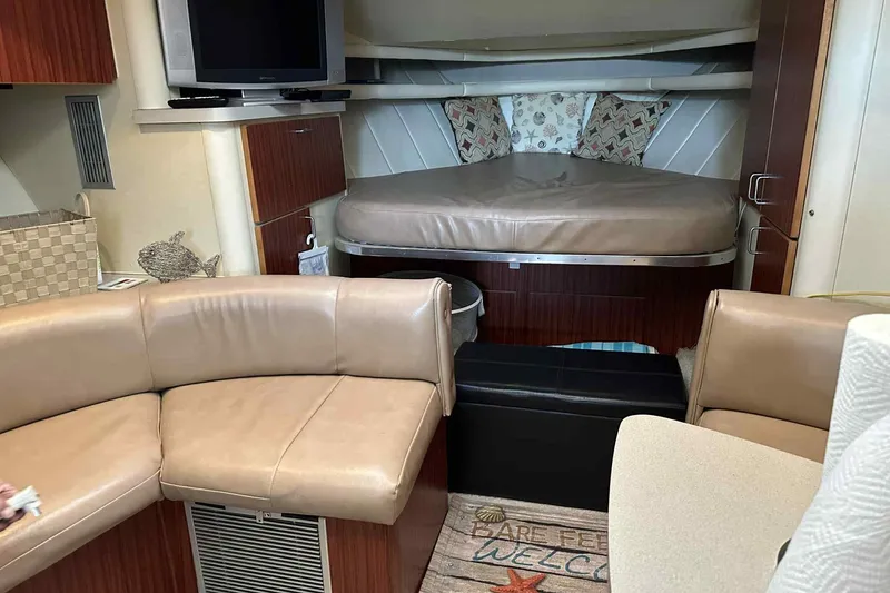 Slide: The Image of 1993 Mainship 39 Express interior with cozy seating, bed, and TV. - 11