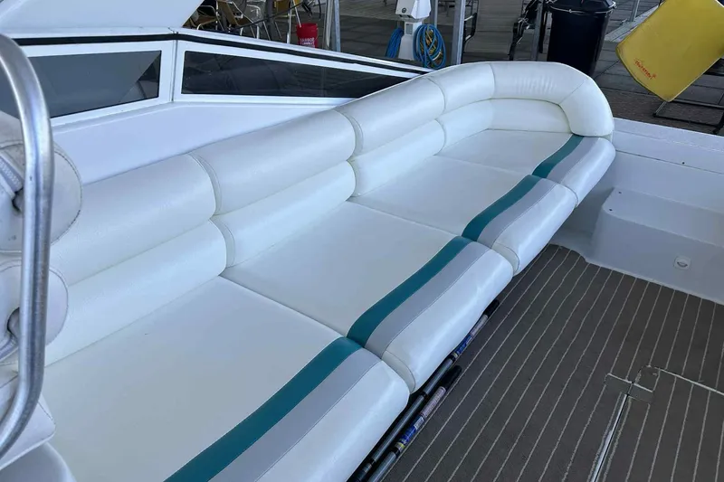 Slide: The Image of 1993 Mainship 39 Express boat with white cushioned seating and teal accents. - 12