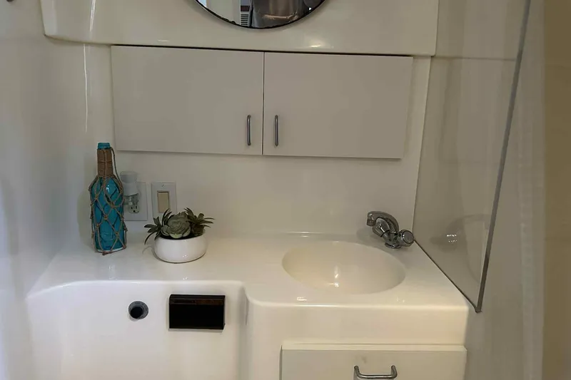 Slide: The Image of Bathroom sink area in 1993 Mainship 39 Express yacht with decor and storage. - 2