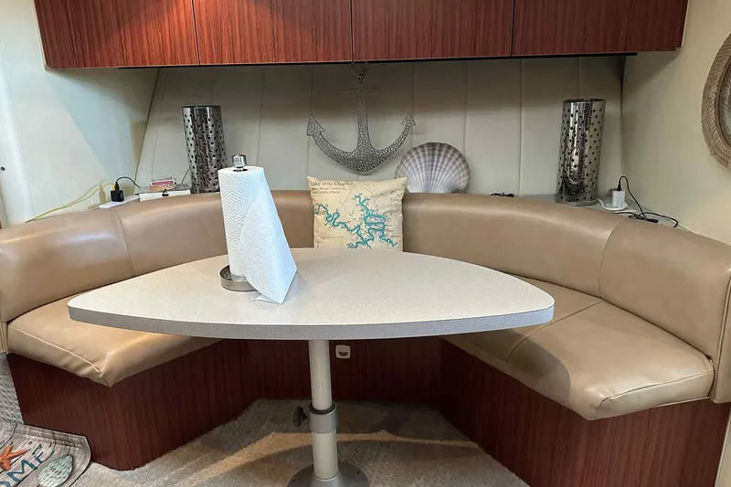 Slide: The Image of 1993 Mainship 39 Express interior with beige seating, table, and nautical decor. - 28