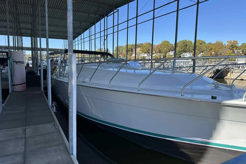 Slide: The Image of 1993 Mainship 39 Express docked under a covered marina with scenic background. - 32