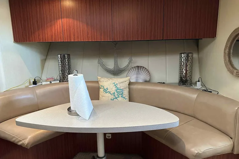 Slide: The Image of 1993 Mainship 39 Express interior with beige seating, table, and nautical decor. - 34
