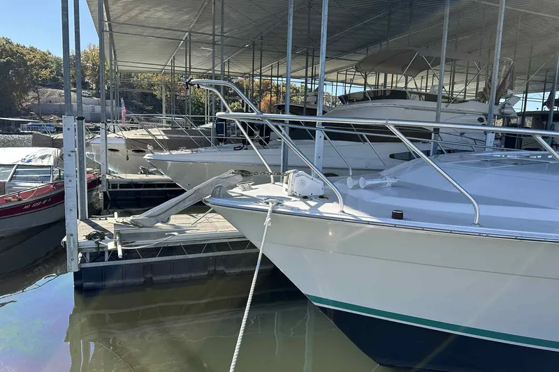 Slide: The Image of 1993 Mainship 39 Express docked in a covered marina, surrounded by other boats. - 37