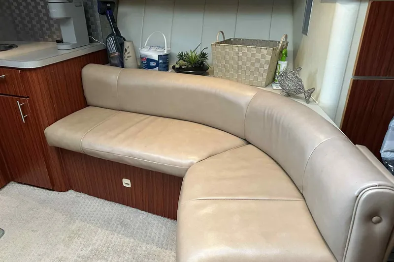 Slide: The Image of 1993 Mainship 39 Express interior with curved beige leather seating and wooden cabinetry. - 46
