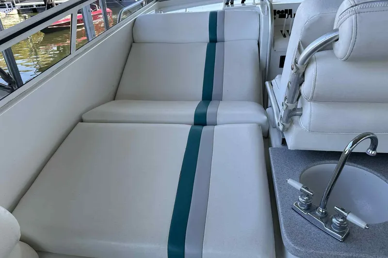 Slide: The Image of 1993 Mainship 39 Express boat interior with white seating and a small sink. - 7