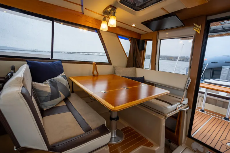 Slide: The Image of Interior of 2016 Cutwater 30 CB boat with cozy seating and wooden table. - 2