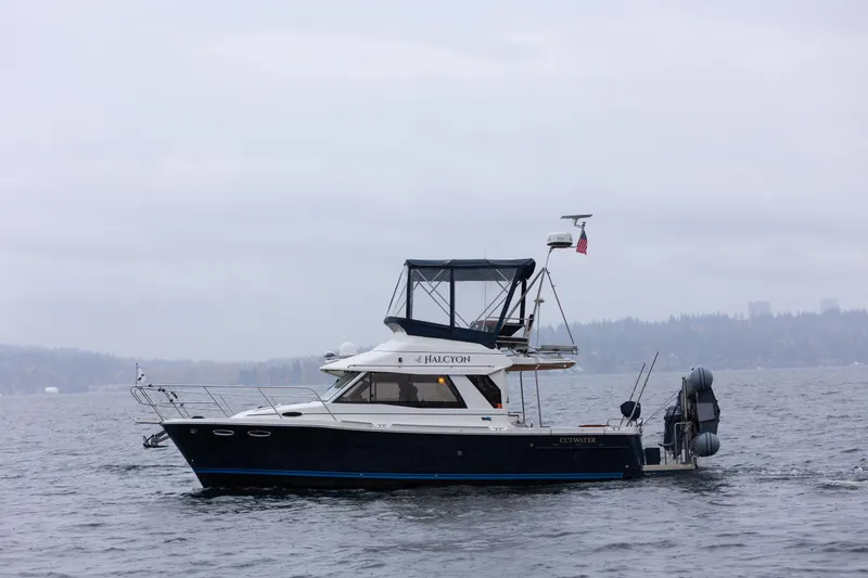 Slide: The Image of 2016 Cutwater 30 CB boat cruising on a cloudy day, with distant shoreline. - 26