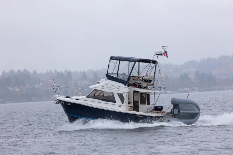 Slide: The Image of 2016 Cutwater 30 CB boat cruising on a misty lake with American flag. - 27