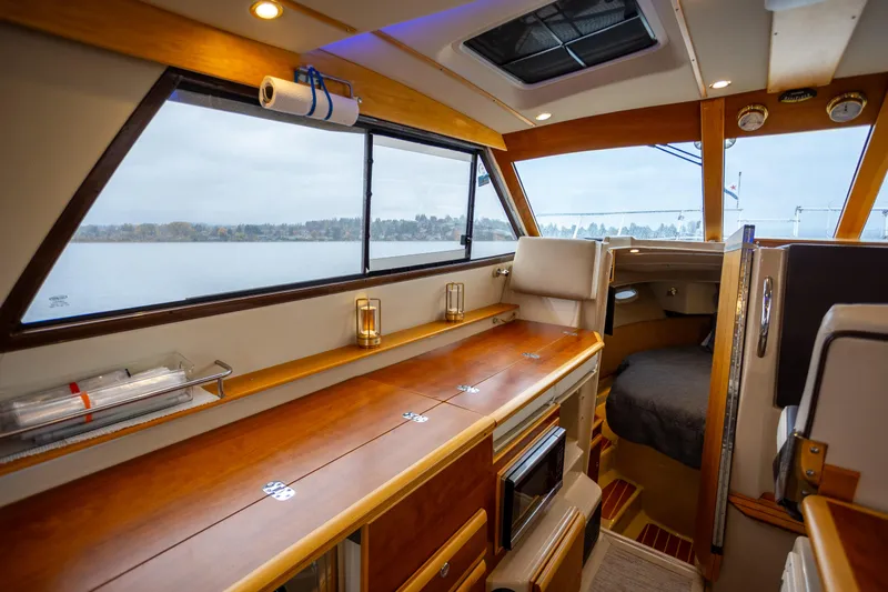 Slide: The Image of Interior of 2016 Cutwater 30 CB boat with wood finishes and large windows. - 7