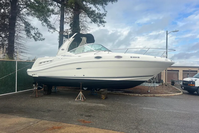 The Image of 2007 Sea Ray 260 Sundancer boat on stands in a parking lot. - 0