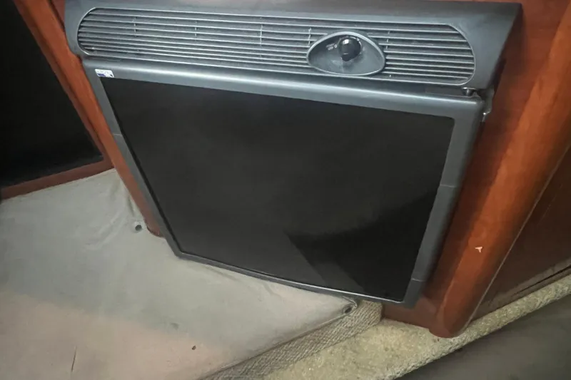 Slide: The Image of 2007 Sea Ray 260 Sundancer interior fridge, black door, wooden paneling. - 10