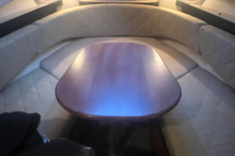 Slide: The Image of Interior cabin of 2007 Sea Ray 260 Sundancer with wooden table and cushioned seating. - 14